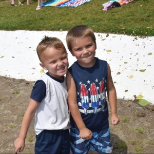 two little boys posing for the camera on the beach