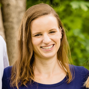 Caucasian woman with light brown hair a blue shirt on smiling